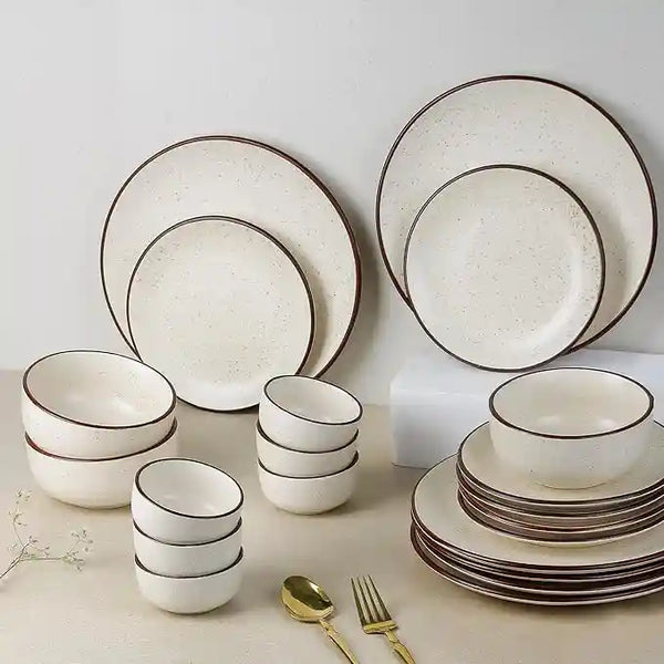 Set of ceramic dinnerware with black rim on a light background