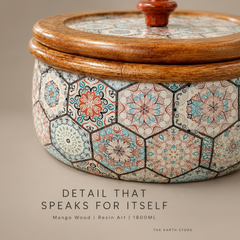 Close-up of a decorative lidded container with a mango wood rim and lid, featuring a hexagonal mosaic tile pattern in beige, blue, orange, and black. Text overlay at the bottom reads 'DETAIL THAT SPEAKS FOR ITSELF' and 'Mango Wood | Resin Art | 180ML'.